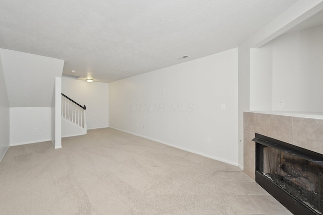 1143 Green Knoll Dr, Westerville, OH 43081 - unfurnished living room featuring stairs, carpet flooring, baseboards, visible vents, and a tile fireplace