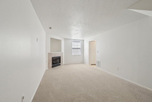 1143 Green Knoll Dr, Westerville, OH 43081 - unfurnished living room with a textured ceiling, visible vents, a tiled fireplace, and light carpet