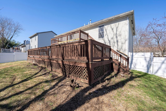 back of property featuring a lawn, a wooden deck, and fence