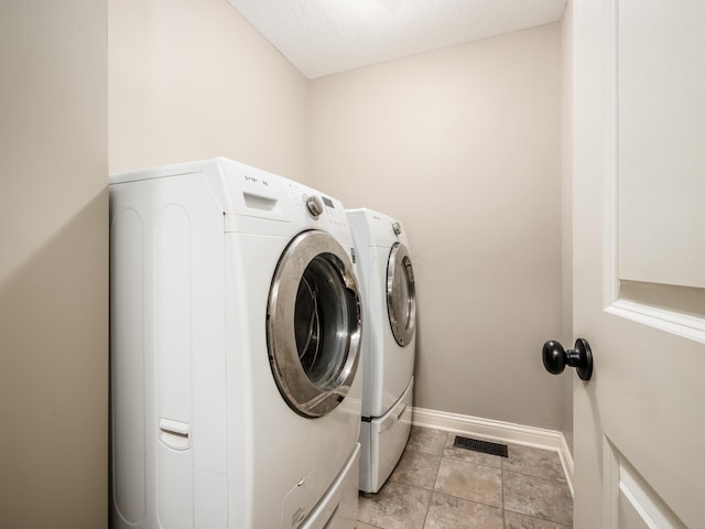 washroom with washer and dryer, laundry area, baseboards, and visible vents