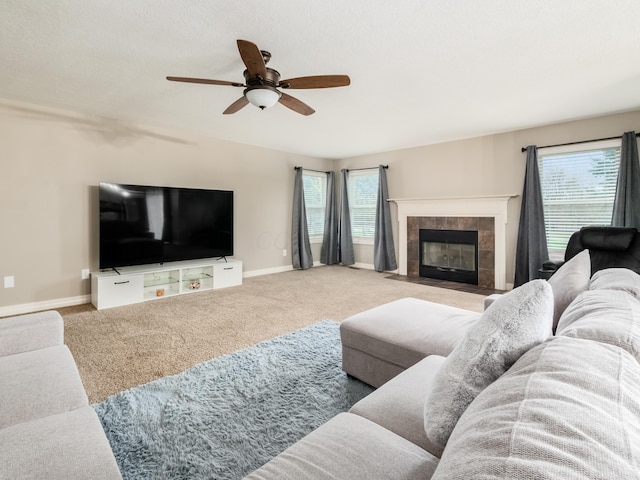 carpeted living area featuring a fireplace, baseboards, and ceiling fan
