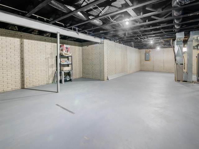 unfinished basement with brick wall, heating unit, and electric panel