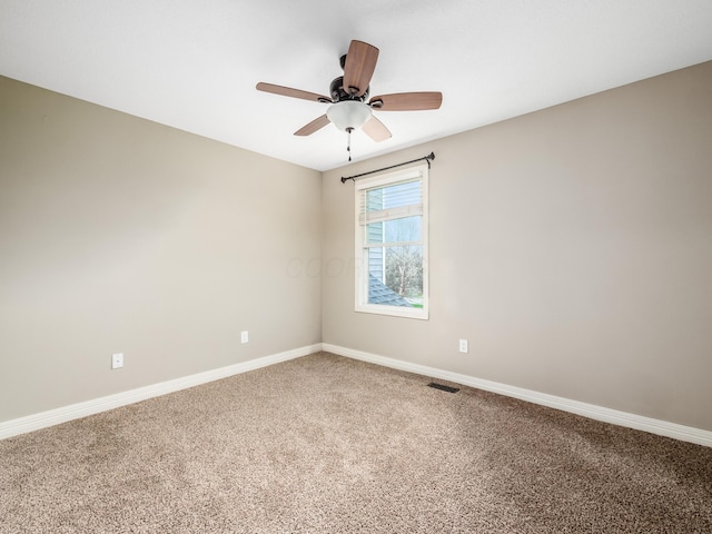 spare room with visible vents, baseboards, ceiling fan, and carpet floors