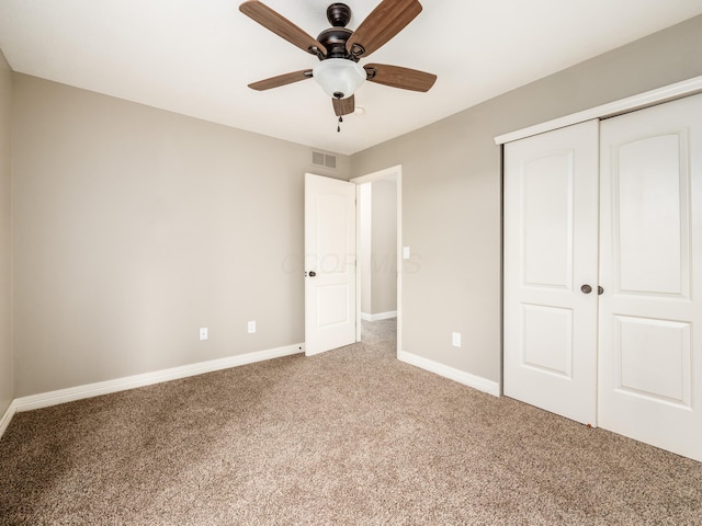 unfurnished bedroom with a closet, baseboards, visible vents, ceiling fan, and carpet