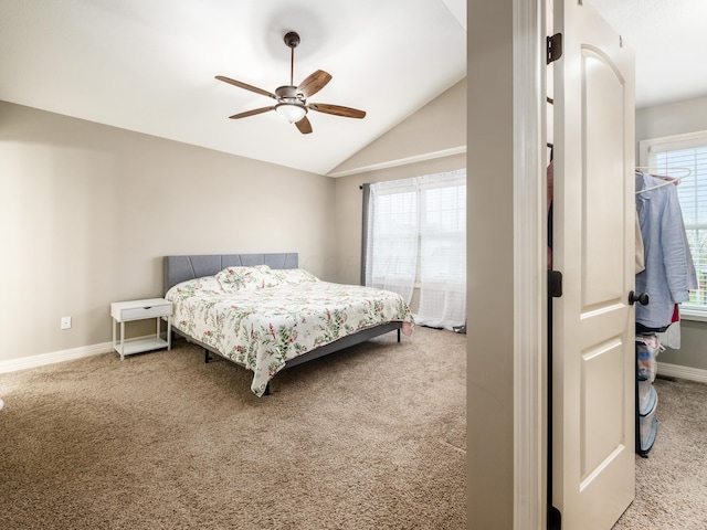 carpeted bedroom featuring baseboards, vaulted ceiling, and a ceiling fan