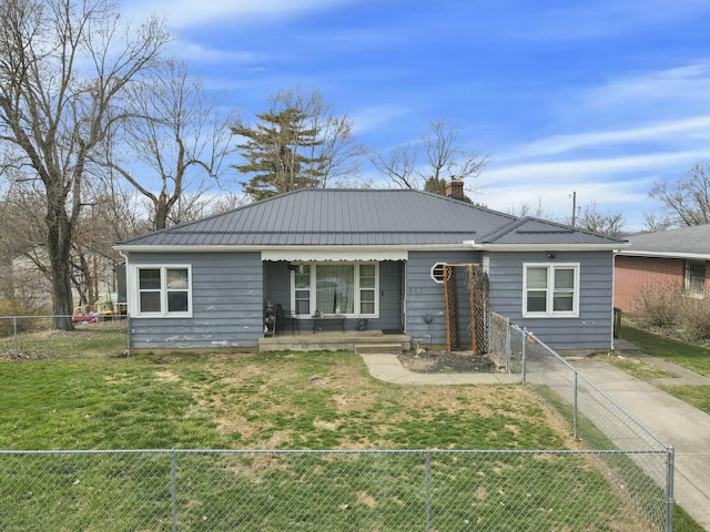 single story home with a chimney, a front lawn, metal roof, a fenced front yard, and a porch