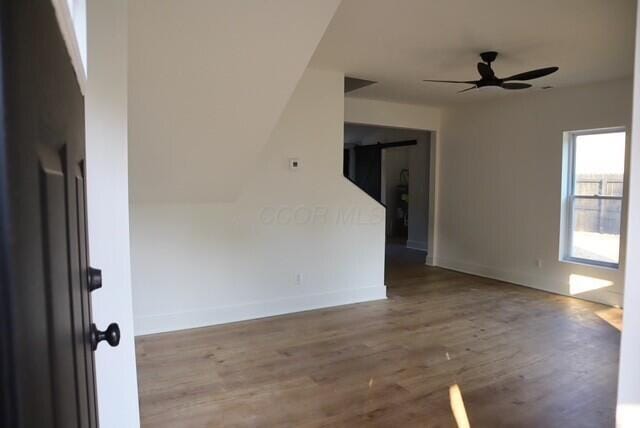 16786 Main St, Williamsport, OH 43164 - unfurnished room featuring wood finished floors, ceiling fan, and a barn door