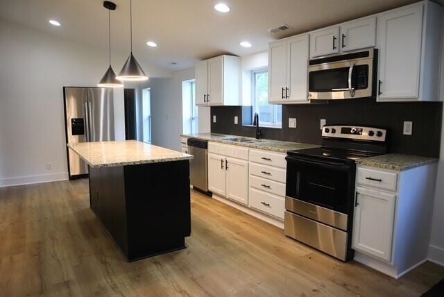 16786 Main St, Williamsport, OH 43164 - kitchen with stainless steel appliances, a center island, light wood-type flooring, light stone counters, and recessed lighting