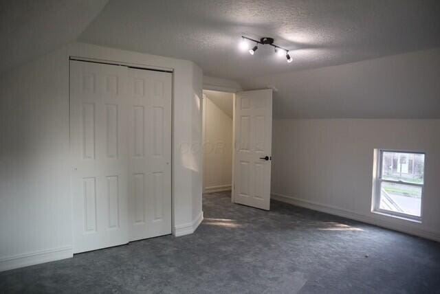 16786 Main St, Williamsport, OH 43164 - unfurnished bedroom featuring lofted ceiling, carpet, a textured ceiling, and a closet