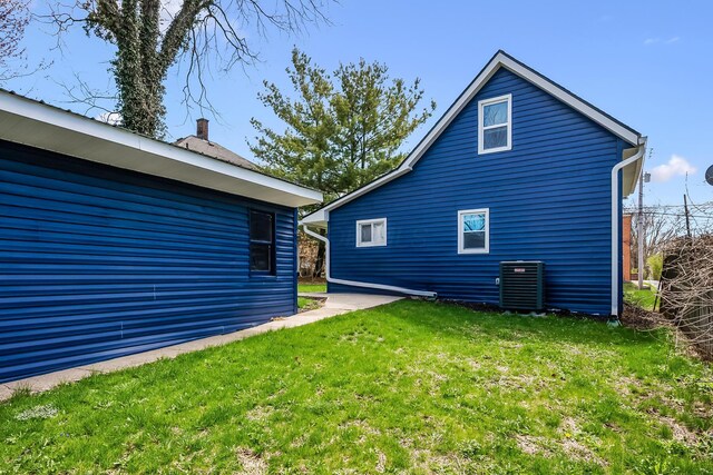 exterior space with central AC unit and a lawn