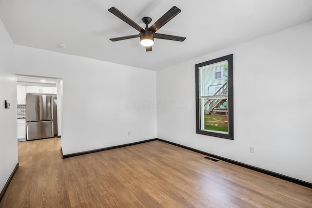 unfurnished room featuring visible vents, baseboards, a ceiling fan, and light wood finished floors