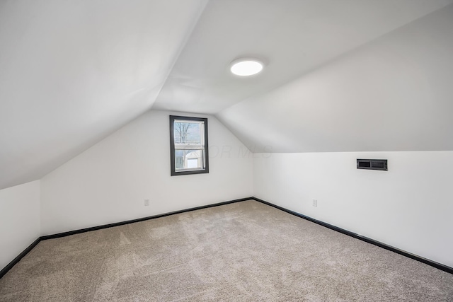 bonus room with carpet, baseboards, vaulted ceiling, and visible vents