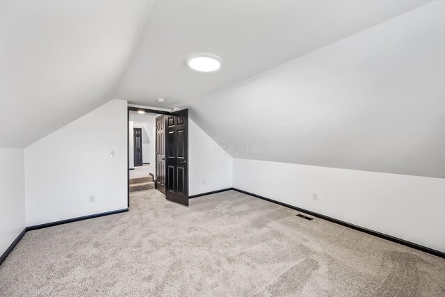 bonus room with visible vents, baseboards, carpet, and lofted ceiling