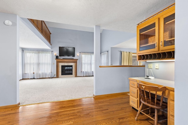 2816 Quail Run Ct, Mansfield, OH 44904 - home office with a textured ceiling, a tiled fireplace, plenty of natural light, built in desk, and wood finished floors