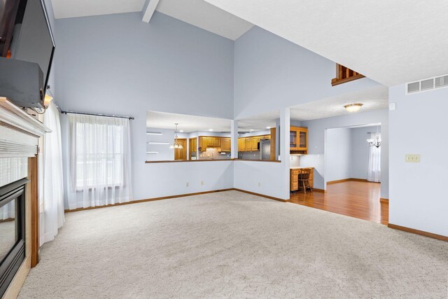 2816 Quail Run Ct, Mansfield, OH 44904 - unfurnished living room featuring carpet floors, a chandelier, a tile fireplace, high vaulted ceiling, and beam ceiling