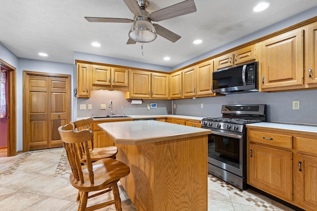 2816 Quail Run Ct, Mansfield, OH 44904 - kitchen with black microwave, stainless steel range with gas stovetop, a center island, light countertops, and ceiling fan