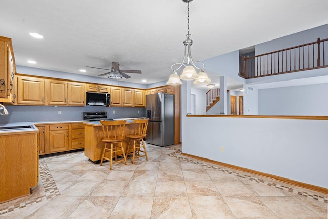 2816 Quail Run Ct, Mansfield, OH 44904 - kitchen with appliances with stainless steel finishes, a center island, ceiling fan, a breakfast bar, and light countertops