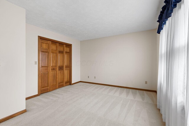 2816 Quail Run Ct, Mansfield, OH 44904 - unfurnished bedroom with light colored carpet, a closet, and a textured ceiling