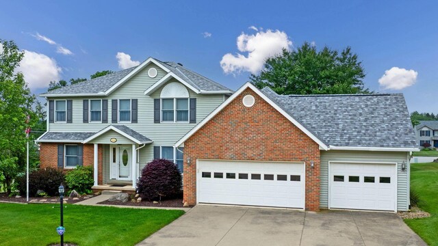 2816 Quail Run Ct, Mansfield, OH 44904 - traditional home with driveway, brick siding, an attached garage, roof with shingles, and a front lawn