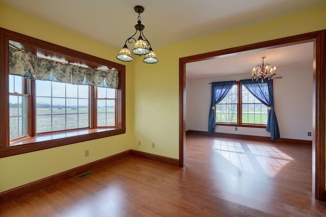 2085 US Highway 62 NE, Washington Court House, OH 43160 - empty room featuring visible vents, a notable chandelier, baseboards, and wood finished floors