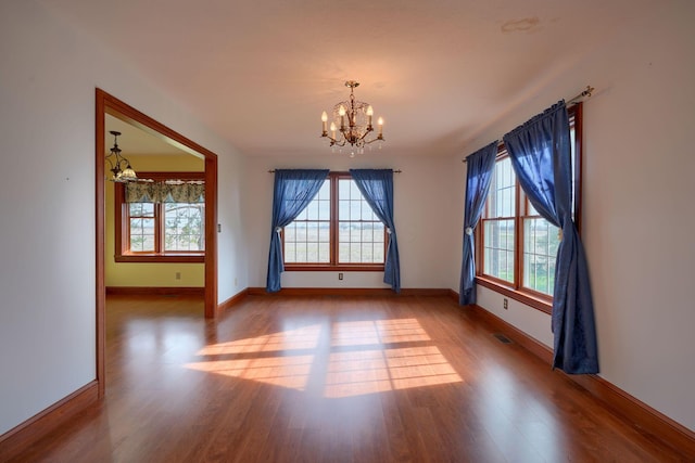2085 US Highway 62 NE, Washington Court House, OH 43160 - unfurnished room featuring wood finished floors, visible vents, a notable chandelier, and a wealth of natural light