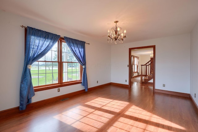 2085 US Highway 62 NE, Washington Court House, OH 43160 - spare room with visible vents, baseboards, wood finished floors, stairway, and an inviting chandelier