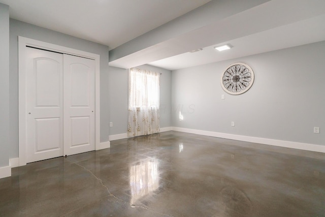 unfurnished bedroom featuring baseboards, a closet, and finished concrete floors