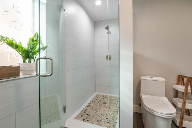 bathroom featuring toilet and a stall shower