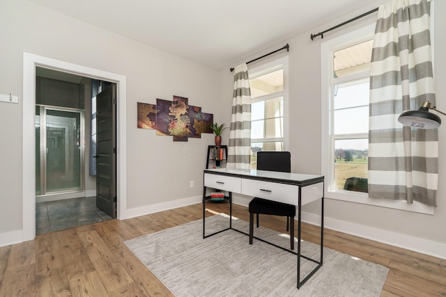 office area with baseboards and wood finished floors