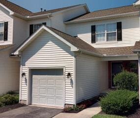 view of side of property with a garage and concrete driveway