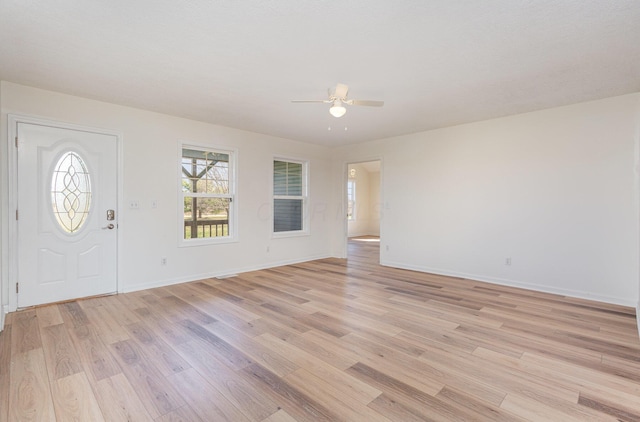 entrance foyer featuring baseboards, a ceiling fan, and light wood finished floors