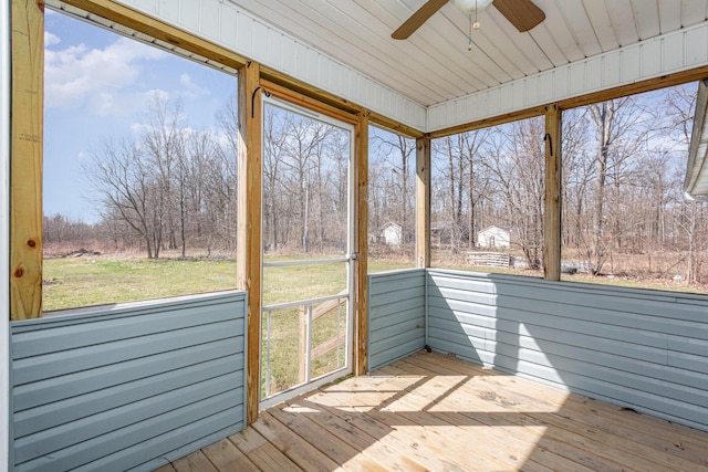 unfurnished sunroom featuring ceiling fan and a healthy amount of sunlight