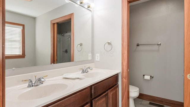 bathroom featuring visible vents, a sink, toilet, and double vanity