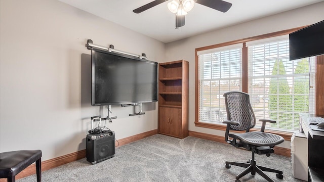 carpeted home office featuring baseboards and a ceiling fan
