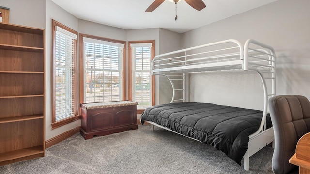 carpeted bedroom featuring baseboards, multiple windows, and a ceiling fan