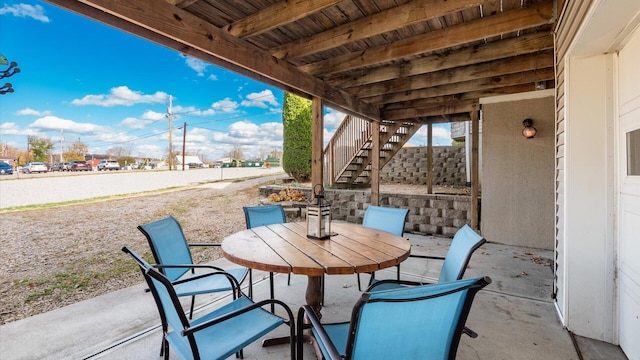 view of patio / terrace featuring outdoor dining area and stairway