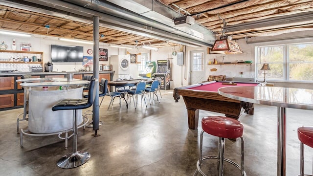game room with pool table, finished concrete floors, and indoor bar