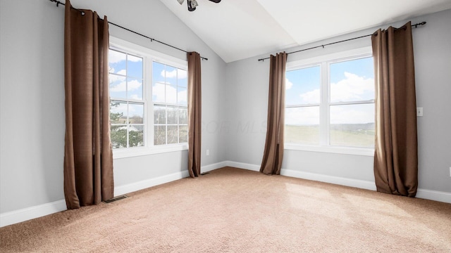 empty room with lofted ceiling, light carpet, and plenty of natural light