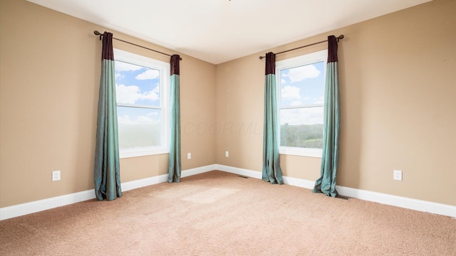 carpeted empty room with baseboards