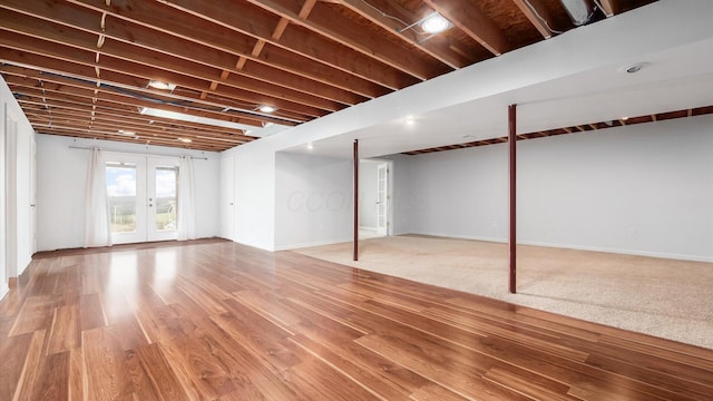 below grade area with baseboards, wood finished floors, and french doors