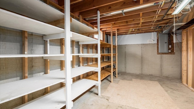 unfinished basement with electric panel and brick wall
