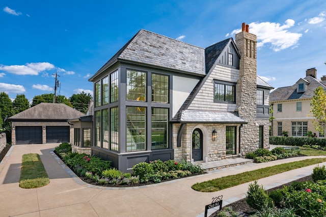 2252 Club Rd, Upper Arlington, OH 43221 - tudor-style house featuring a high end roof, a detached garage, stone siding, and a chimney