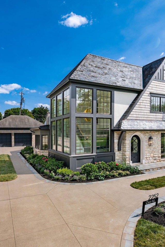 2252 Club Rd, Upper Arlington, OH 43221 - view of side of home with stone siding, a high end roof, and stucco siding