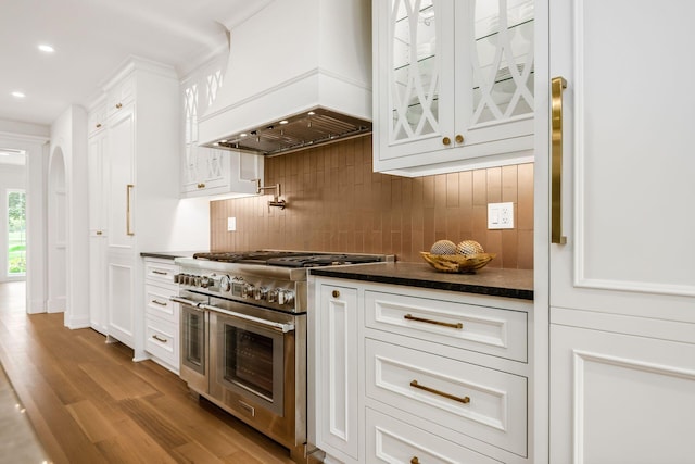 2252 Club Rd, Upper Arlington, OH 43221 - kitchen with custom exhaust hood, recessed lighting, glass insert cabinets, wood finished floors, and range with two ovens
