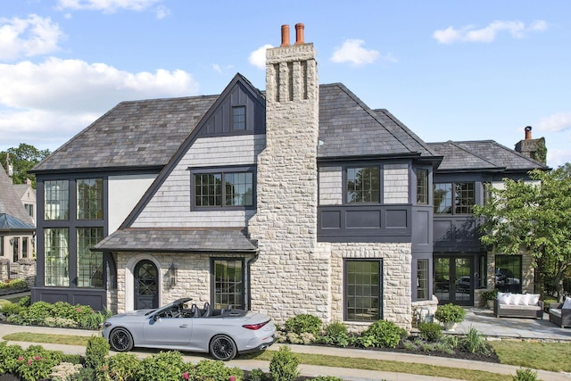 2252 Club Rd, Upper Arlington, OH 43221 - view of front of house featuring a chimney, stone siding, an outdoor hangout area, and french doors