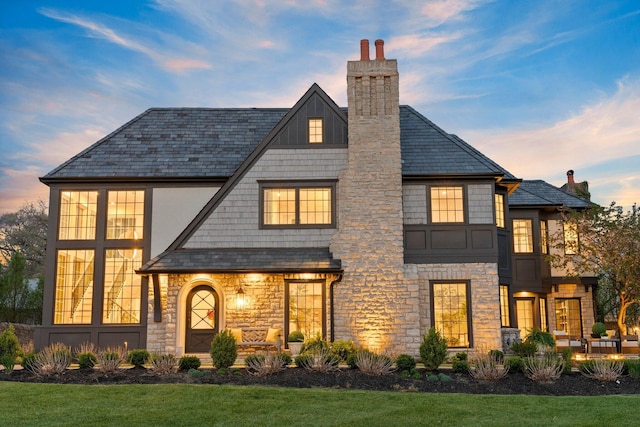 2252 Club Rd, Upper Arlington, OH 43221 - view of front of property with stone siding, a chimney, and a front yard