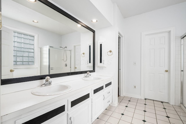 full bathroom featuring double vanity, a sink, a stall shower, and recessed lighting