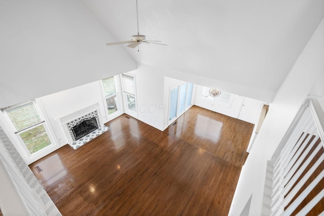 unfurnished living room featuring high vaulted ceiling, a ceiling fan, a fireplace, dark wood finished floors, and visible vents