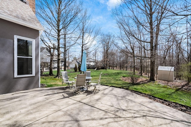 view of patio / terrace featuring outdoor dining space, an outbuilding, and a storage shed