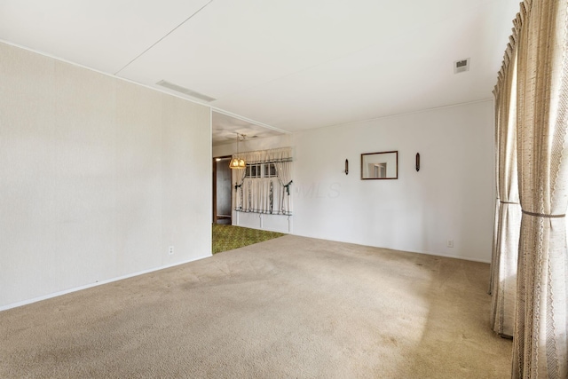 carpeted spare room featuring visible vents
